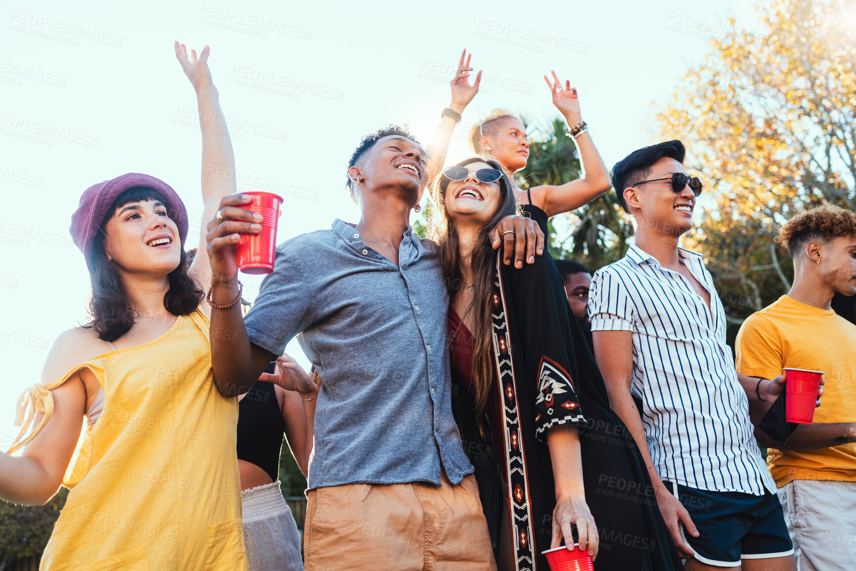 Buy stock photo Drinks, party and a couple of friends dancing outdoor to celebrate at festival, concert or social event. Diversity young men and women people together while happy, singing and drinking alcohol