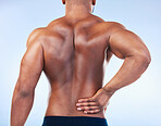 Black man, back pain and injury with fitness and health, medical problem and aching body in studio. Emergency, muscle tension and male athlete with joint ache from workout on blue background