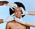 Confused, hands and black woman with check on a blue background for plastic surgery or dermatology problem. Frustrated, African girl and doctors and inspection of skin isolated on a studio backdrop