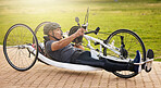 Fitness, cycling and a man with a disability in nature on a bike for training, travel and exercise. Sports, street and a person in a wheelchair bicycle for a workout, health or cardio in a park