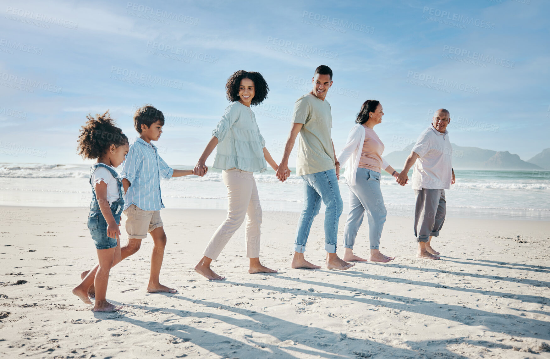 Buy stock photo Walking, holding hands and family outdoor on a beach with love, care and happiness on travel vacation. Parents, grandparents or men and women with children at sea for holiday, journey or adventure