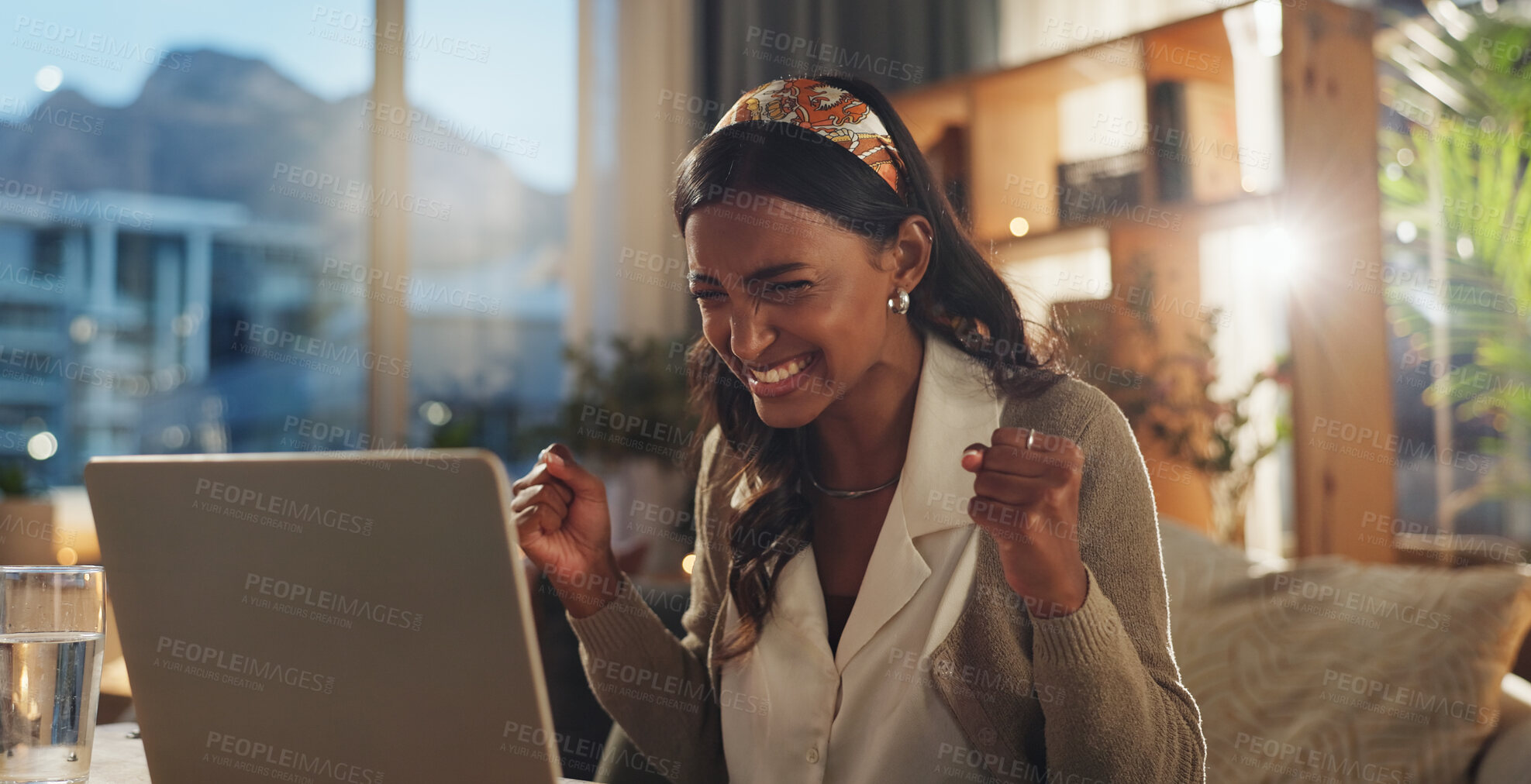 Buy stock photo Employee, Indian woman and happy with laptop in home office for good news, bonus and job promotion. Female person, smile and excited at night with email for career opportunity and interview success