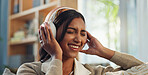 Headphones, indian woman and music for relax in home, listen and signing with song in living room. Joyful, break and musician for female person and practice in lounge, artist and vocal warmup on sofa