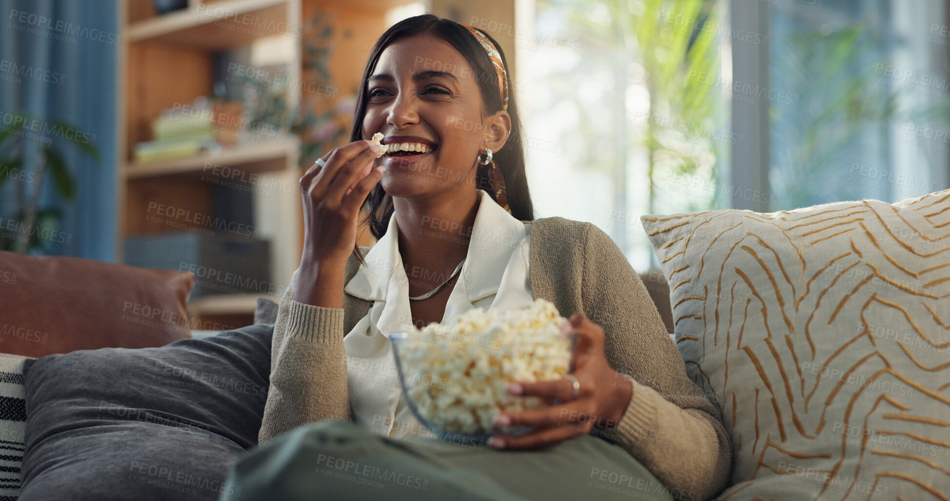 Buy stock photo Happy, girl and relax on sofa with popcorn for watching movies, streaming comedy film and unwind on weekend for break. Woman, laughing and snack in home for online subscription and entertainment.