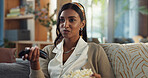 Indian woman, home and watching television with popcorn on streaming platform for movies or series. Female person, tv remote and smile or happy with snack for subscription, fun and enjoy on sofa