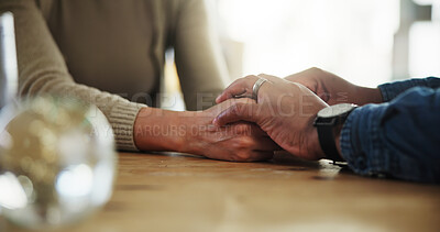 Buy stock photo Holding hands, couple and support on table, home and promise of love, compassion and communication. House, trust and mature people with empathy, care and respect for relationship, commitment or loyal