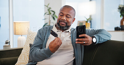 Buy stock photo Mature black man, home and phone with credit card for online shopping, discount and sale. Password information, ecommerce and typing on fintech app or banking with rewards, voucher code and savings