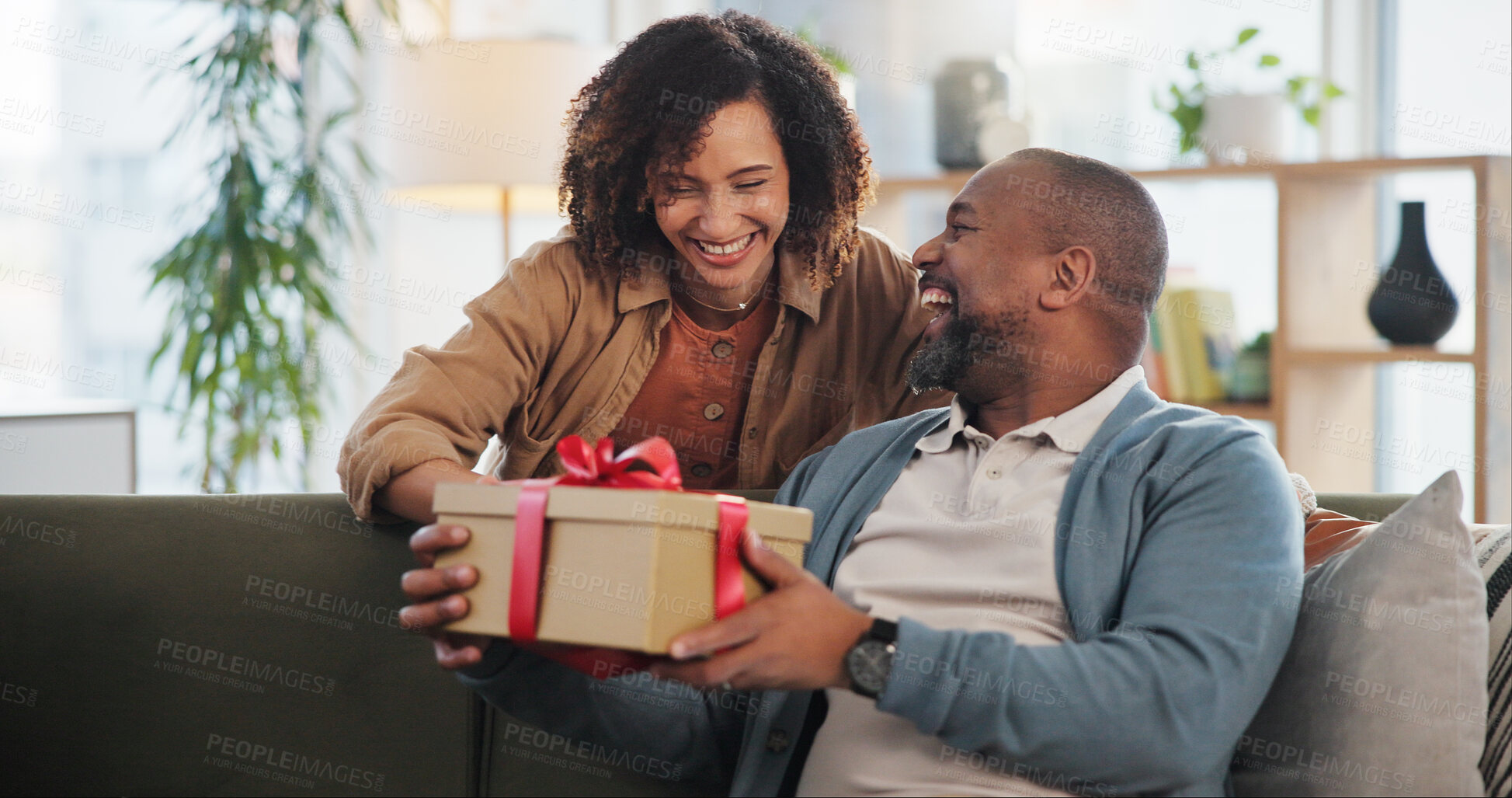 Buy stock photo Love, gift and smile with couple on sofa for festive holiday, celebration and Christmas. Surprise, vacation and giving present with man and woman with box in living room of home for xmas and romance
