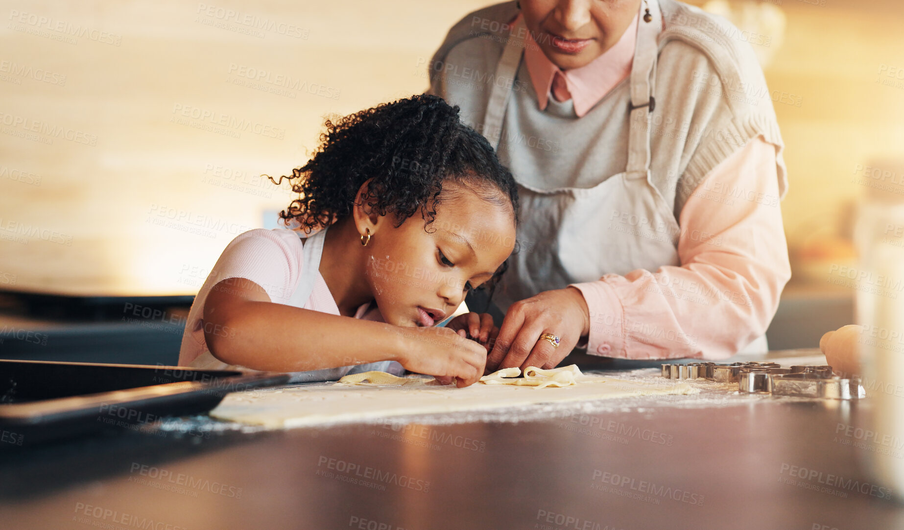 Buy stock photo Grandparent, little girl and baking with cookie cutter on table in kitchen for learning, teaching or making dough at home. Grandma, child or junior baker with shapes for dessert or recipe at house