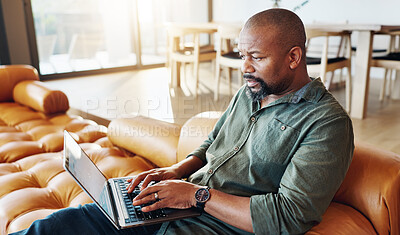 Buy stock photo Home, laptop and man on sofa, typing and internet with connection, website info and digital app. African person, apartment or guy on couch, research for insurance policy or email with online news