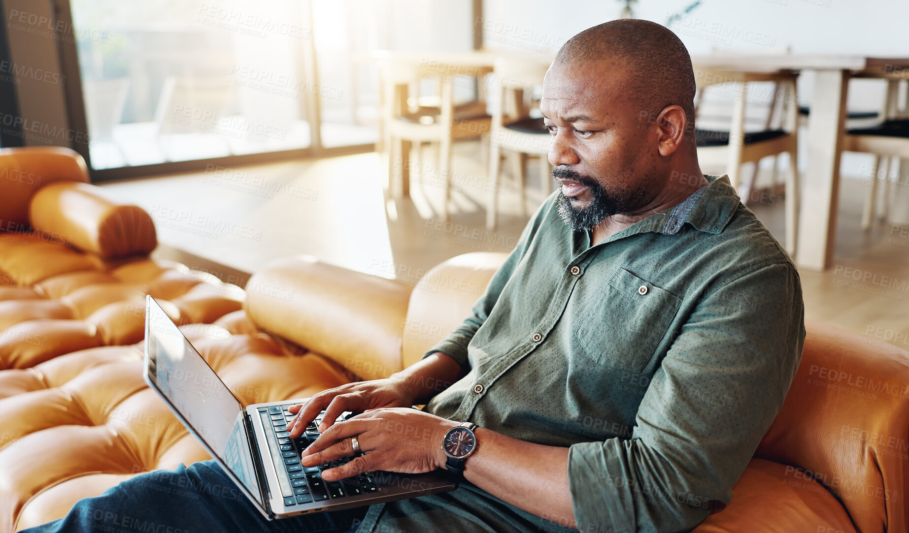 Buy stock photo Home, laptop and man on sofa, typing and internet with connection, website info and digital app. African person, apartment or guy on couch, research for insurance policy or email with online news