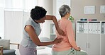 Woman, physiotherapist and patient with back pain for injury or medical consultation at clinic. Female person, orthopedic and senior client with sore spine, ache or muscle tension at private practice