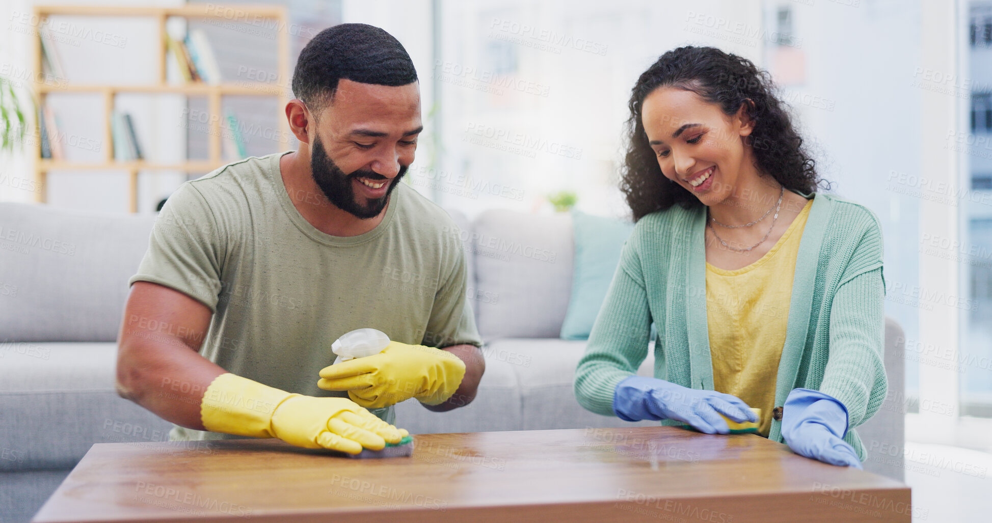 Buy stock photo Couple, spray and cleaning for table in home with smile with sponge, shine and polish in living room. Man, woman and happy for teamwork, bonding and gloves with hygiene, bacteria and wood in house