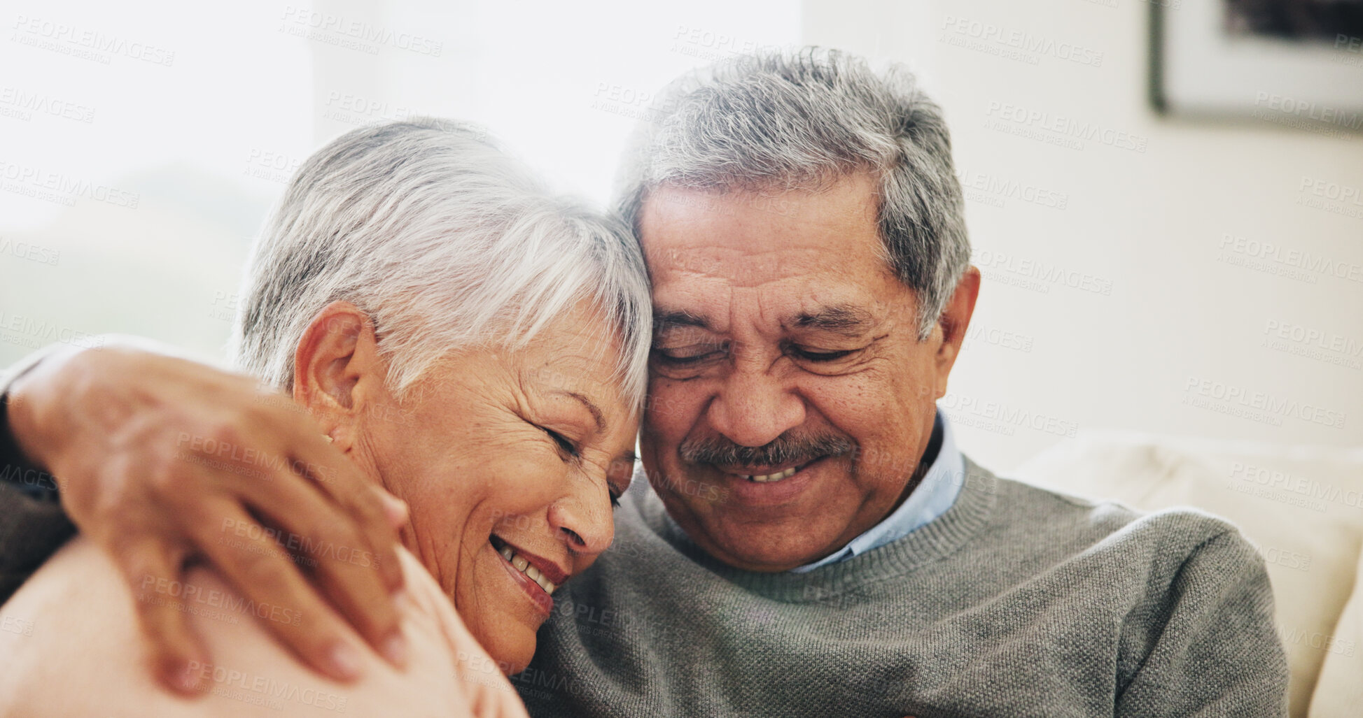 Buy stock photo Hug, care and senior couple in house, love and smile with retirement, happiness and bonding together. Apartment, embrace and mature woman with elderly man on sofa, relax and comfortable in lounge