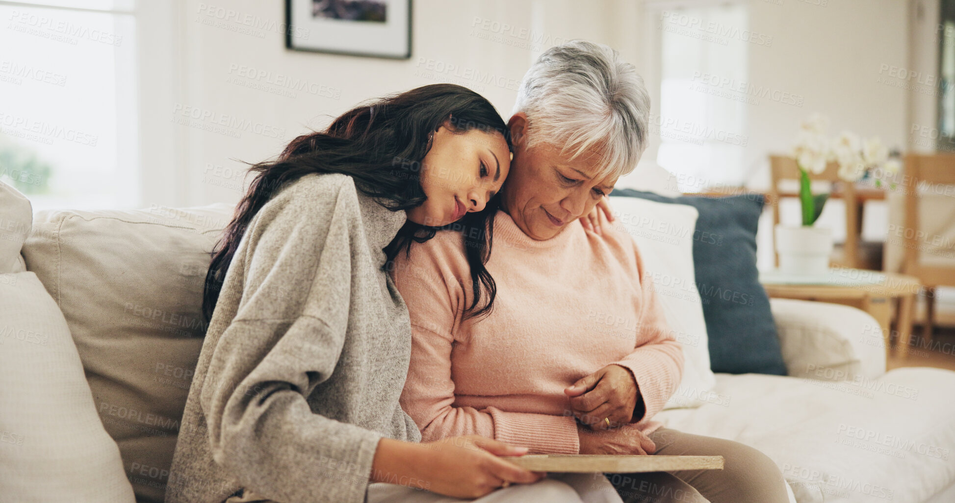 Buy stock photo Women, senior mother and sad with photo frame, hug and empathy for grief, memory and love in lounge. Family, people and embrace with support, trust and comfort in house for depression in retirement