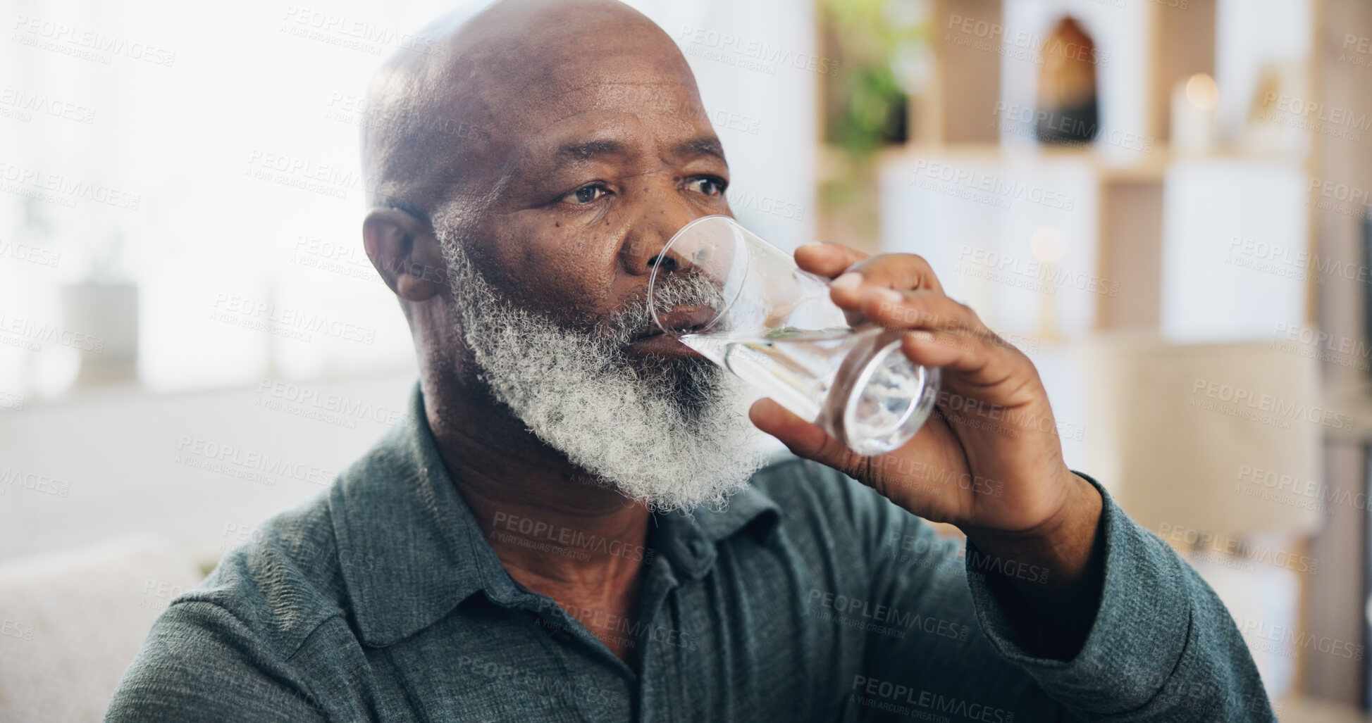 Buy stock photo Drinking water, mature man and hydration in home, lounge and thinking for wellness, liquid and glass. Living room, healthy and fluid for digestion, thirsty and nutrition in house and black person