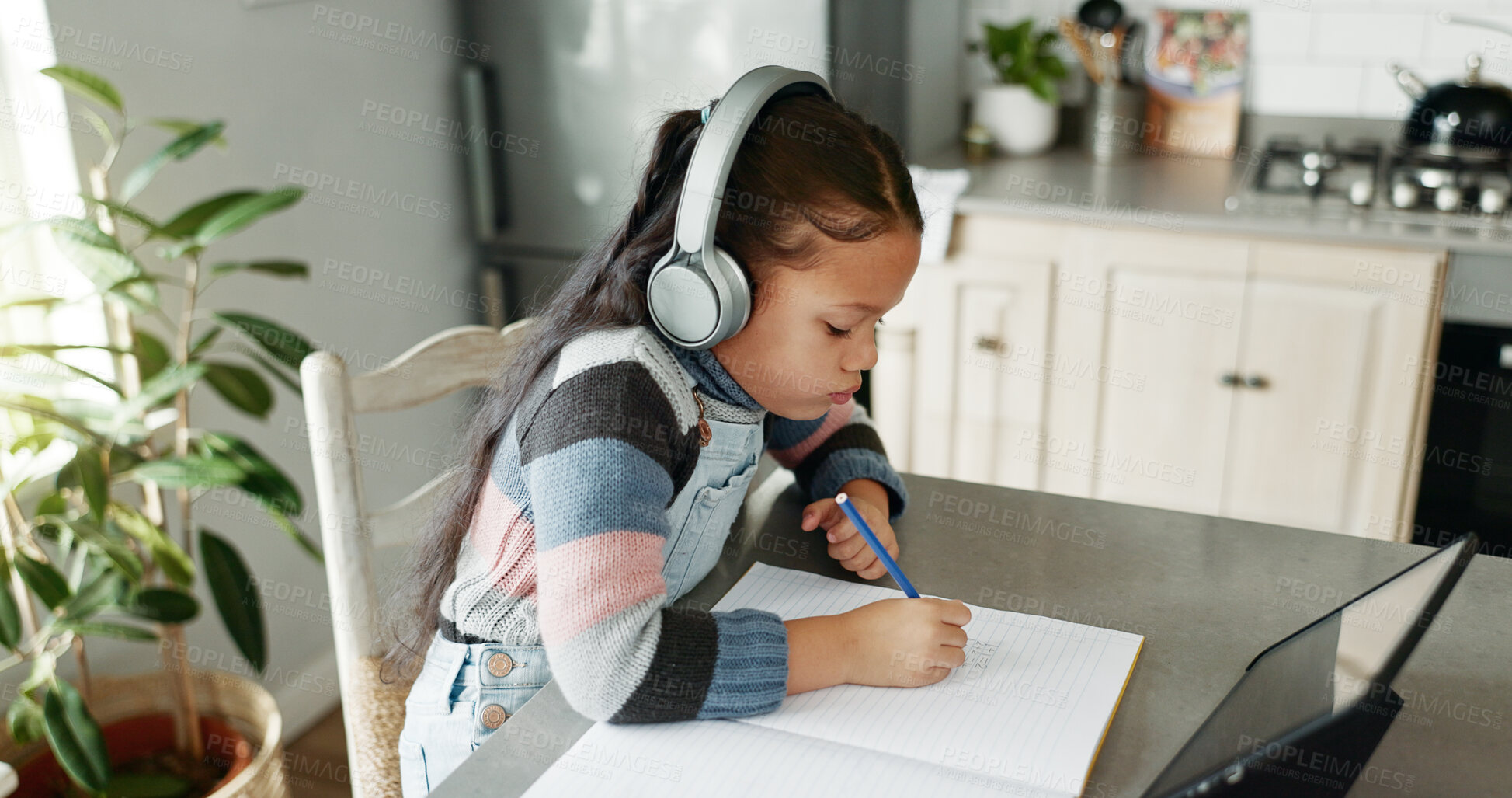 Buy stock photo Girl, home and writing with tablet for online education in kitchen with homework and elearning. Kid, counter and notebook with headphones on virtual class or tutorial for child development and growth