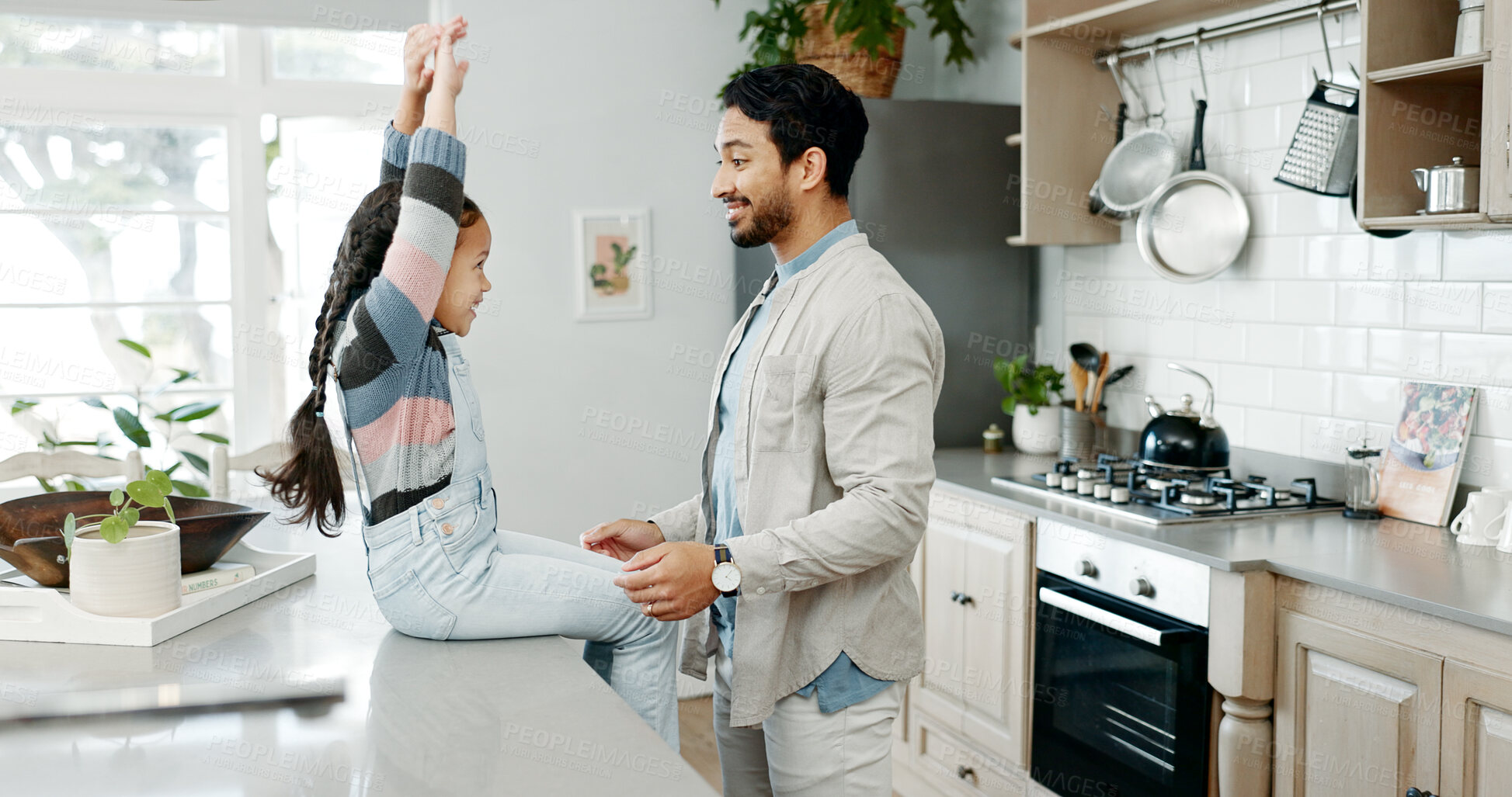 Buy stock photo Dad, girl and happy on kitchen counter in home for bonding, fun and support with playing. People, parent and smile with kid as family on break to relax or rest for child development, care and growth