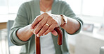 Hands, senior and walking stick for support, health and mobility aid in retirement home. Closeup, cane and person with disability, injury and crutch to help with osteoporosis or arthritis in lounge