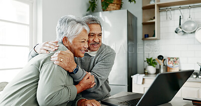 Buy stock photo Senior, happy couple and hug with laptop for retirement, bonding or planning holiday in kitchen at home. Elderly man, woman or lovers with smile on computer for embrace, online booking or getaway