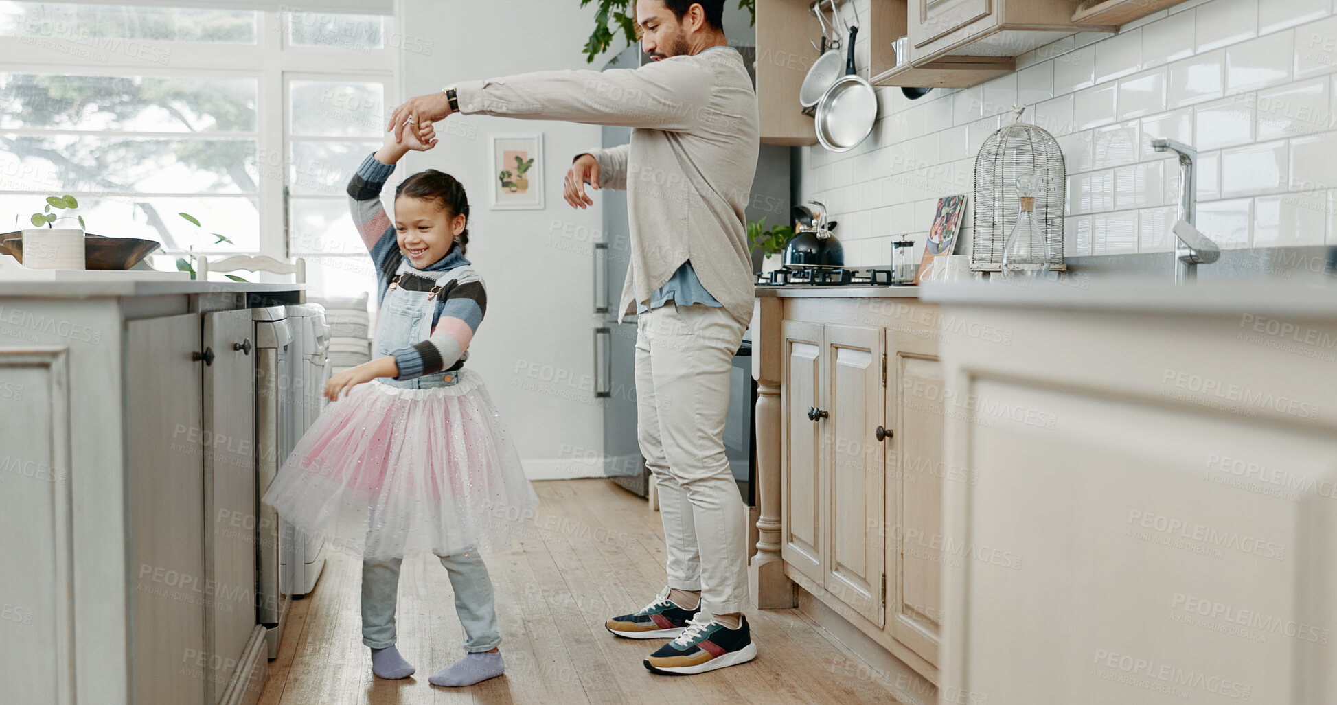 Buy stock photo Girl, ballerina and dancing with father in home, kitchen and holding hands with smile, care and bonding. Man, dad and child with ballet, connection and tutu for funny game with love in family house