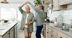 Elderly couple, dancing and love in home, support and holding hands for laughing in kitchen. People, commitment and together for connection in relationship, bonding and romance or loyalty in marriage