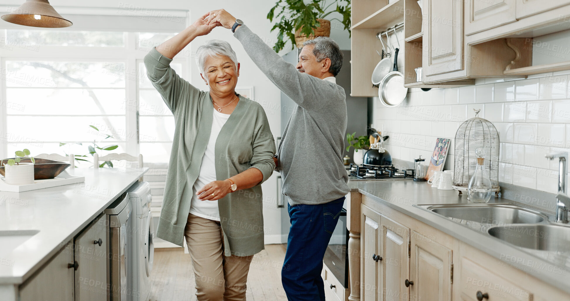 Buy stock photo Elderly couple, dancing and love in home, support and holding hands for laughing in kitchen. People, commitment and together for connection in relationship, bonding and romance or loyalty in marriage