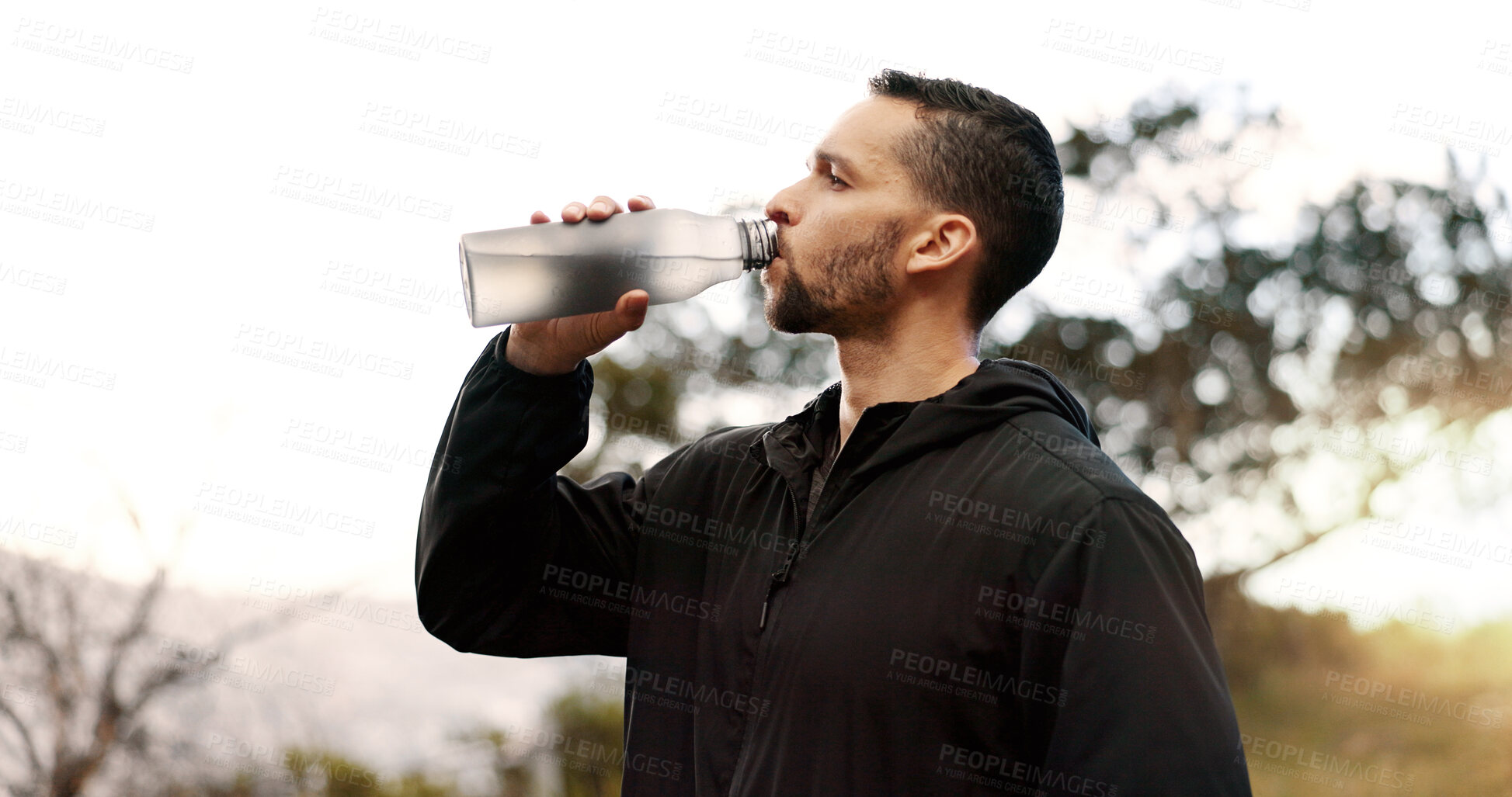 Buy stock photo Man, drinking water or profile in nature for fitness, hydration or electrolytes for energy. Athlete, break or liquid in bottle for refreshment, healthy body or rest from running on mountain in Brazil