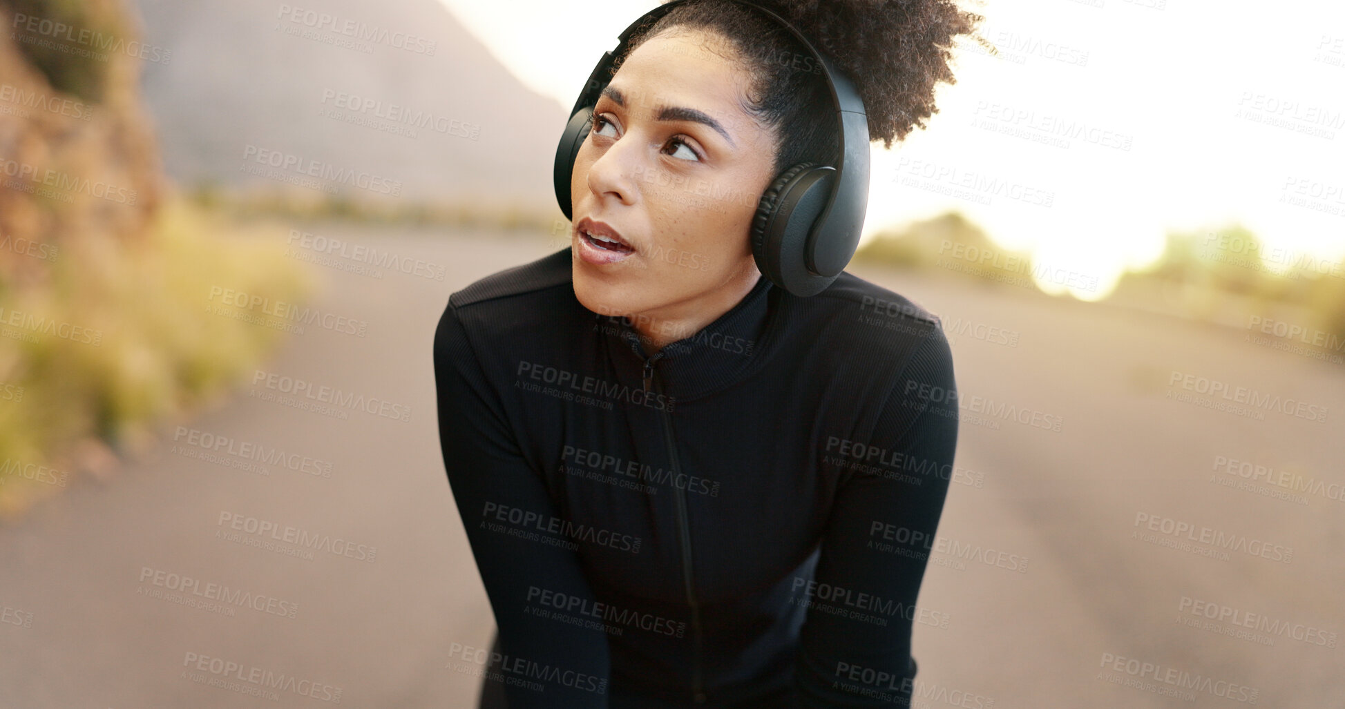 Buy stock photo Thinking, headphones and tired woman with fitness, outdoor and listening to podcast, breathing and sound. Runner, athlete and person with headset, nature and wonder with wellness and mountain road