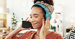 Happy woman, headphones and relax with phone for music, listening or podcast on sofa at home. Young, female person or user enjoying audio streaming, sound track or tune with headset or smile at house
