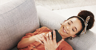 Buy stock photo Happy woman, relax or lying with phone on sofa for social media, online browsing or chatting at home. Young, female person or user with smile on mobile smartphone for texting, message or app at house