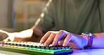 Man, hands and gamer with neon keyboard for esport, match or online tournament on desk at home. Closeup, male person or streamer with peripheral or computer equipment for challenge or playing game