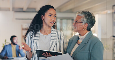 Buy stock photo Women, tablet and discussion at night in office with ideas, review and planning at media company. People, journalist and senior editor with talk for story, notes or advice for headline at news agency