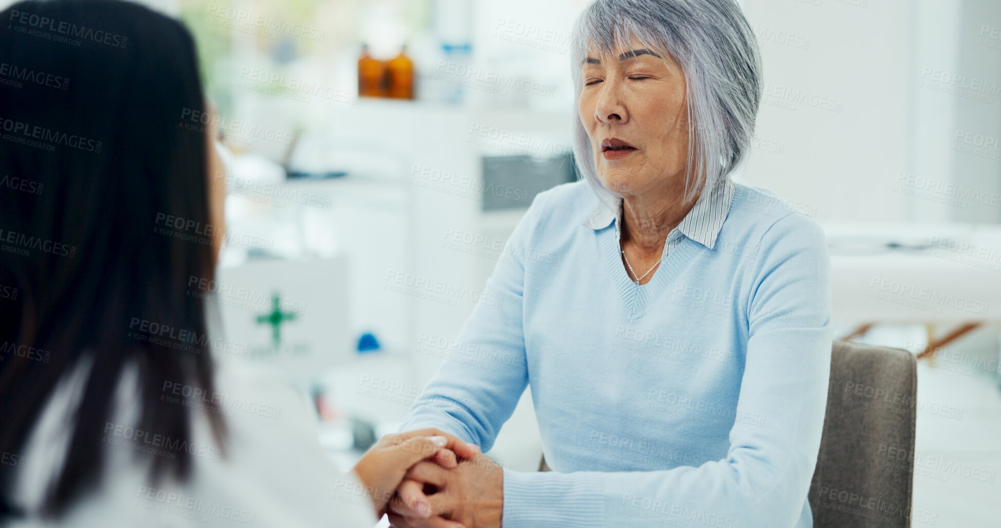 Buy stock photo Holding hands, doctor and patient on consultation with eyes closed for support, feedback and report on diagnosis. People, healthcare and sad for advice, help and communication with kindness at clinic