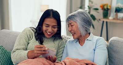 Buy stock photo Senior mom, daughter and happy with photo album at home with laugh on sofa in living room. Retirement, pensioner and smile as parent with bonding, memories and support for unity, love and nostalgic