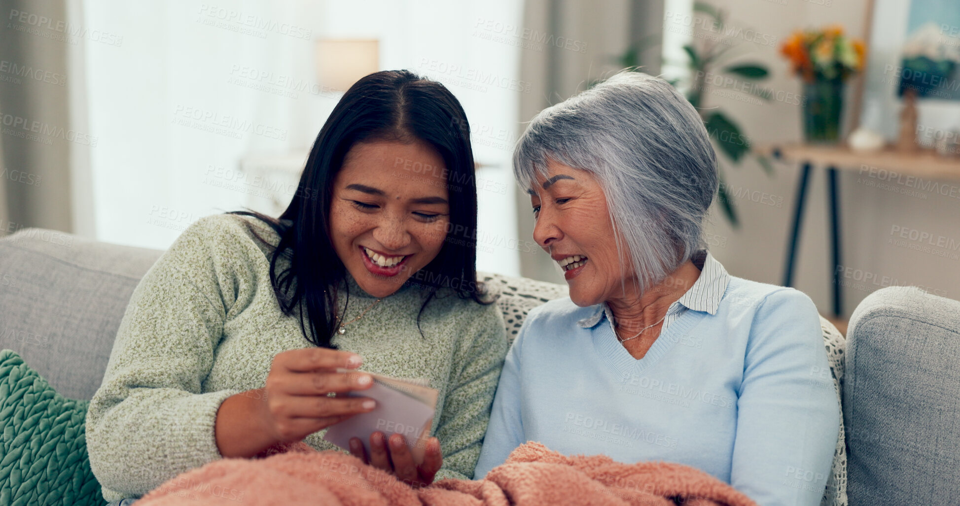 Buy stock photo Senior mom, daughter and happy with photo album at home with laugh on sofa in living room. Retirement, pensioner and smile as parent with bonding, memories and support for unity, love and nostalgic