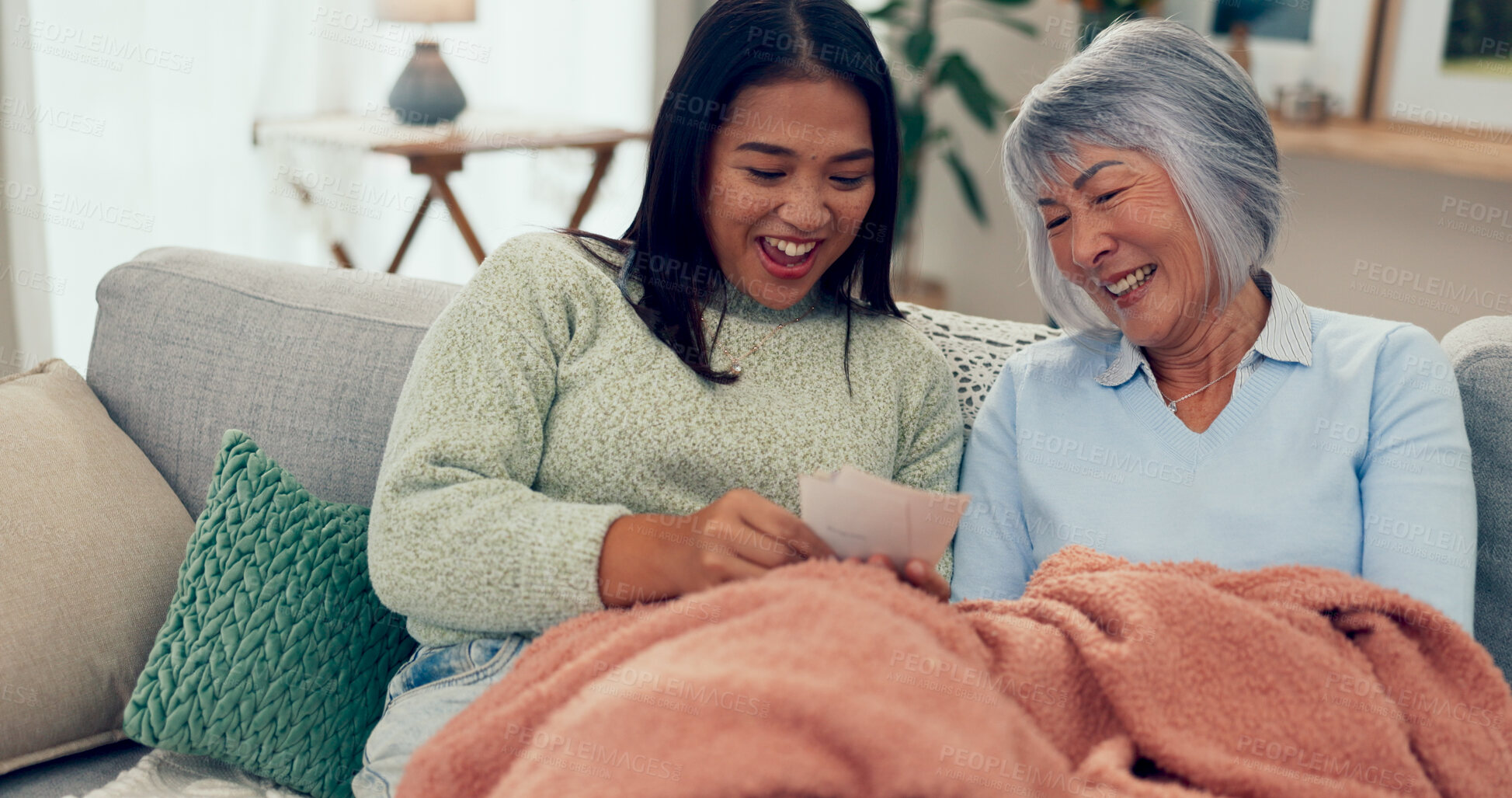 Buy stock photo Senior mom, daughter and laugh with photo album at home with smile on sofa in living room. Retirement, pensioner and happy as parent with bonding, memories and support for unity, love and nostalgic