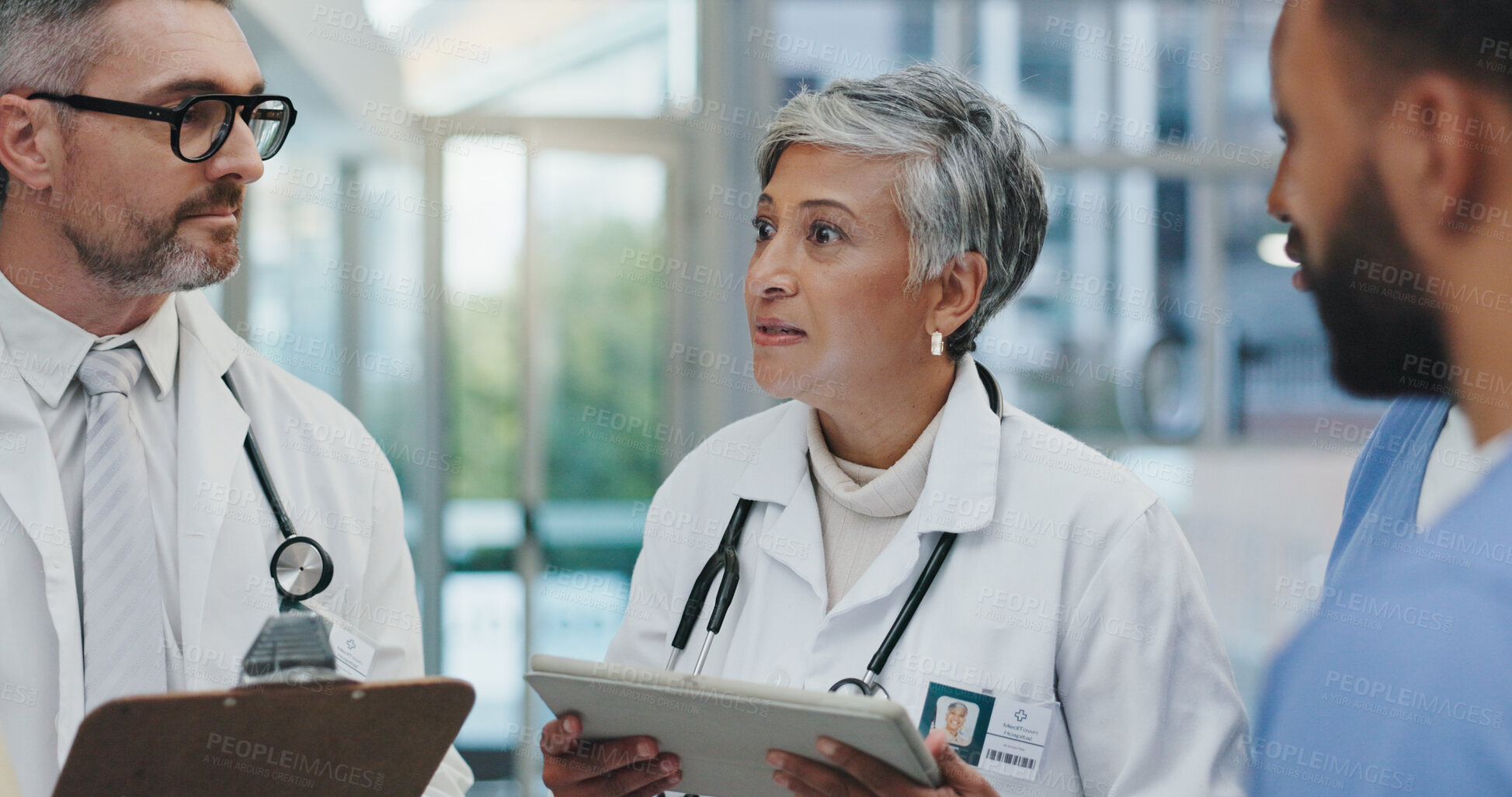 Buy stock photo Meeting, discussion and doctors in clinic with clipboard, tablet and advice for schedule in lobby. Group, men and women together in healthcare for planning, consulting and medical team in hospital