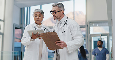 Buy stock photo Tablet, clipboard and doctors in hospital with planning, discussion and advice for schedule in lobby. Healthcare, man and woman meeting, consulting and checking digital app for medical team in clinic