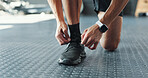 Shoes, hands and man tie laces in gym for workout, training or running for fitness, health or wellness. Sports, cardio and closeup of male athlete getting ready with sneakers for cardio exercise.