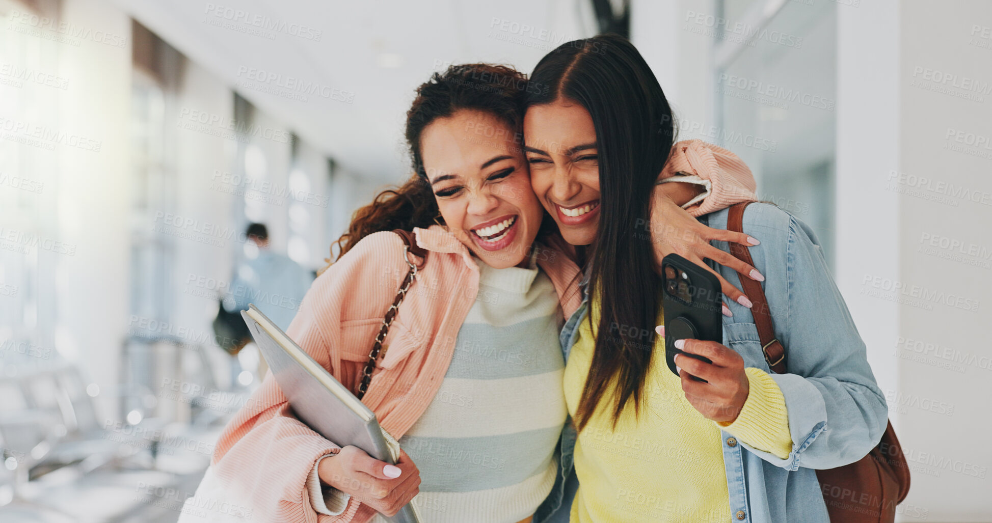 Buy stock photo Friends, happy and excited in university for hug, storytelling and good news on phone. Students, support and mobile in hallway for admission, unexpected notification or acceptance to higher education