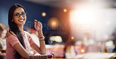 Buy stock photo Portrait of a beautiful university student making notes while sitting in a lecture hall