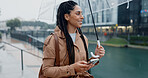 Woman, outdoor and smile with umbrella on smartphone on mobile app for ehailing for taxi ride. Female person, employee and happy online on website for requesting transportation in city with rain