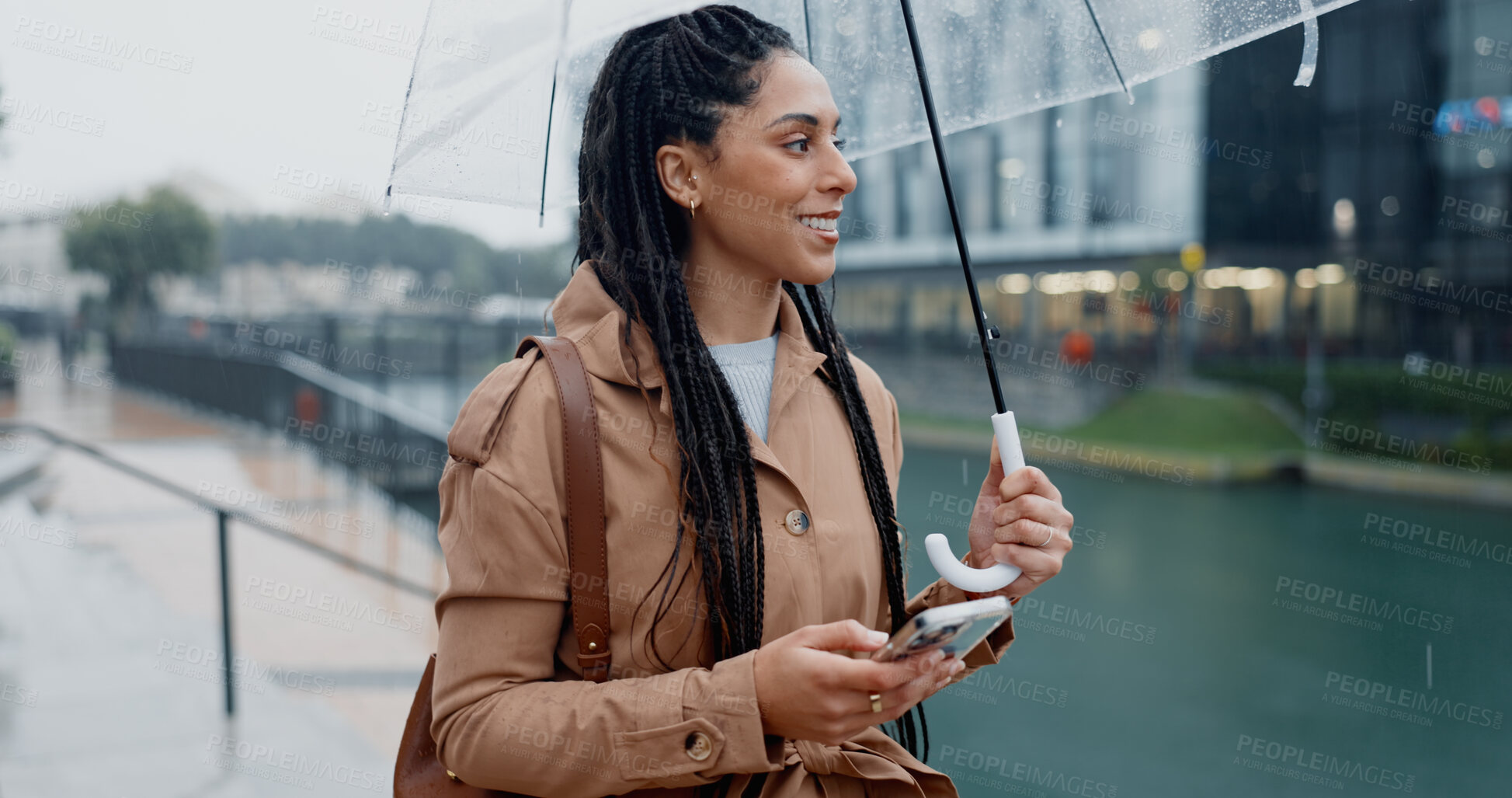 Buy stock photo Woman, outdoor and smile with umbrella on smartphone on mobile app for ehailing for taxi ride. Female person, employee and happy online on website for requesting transportation in city with rain