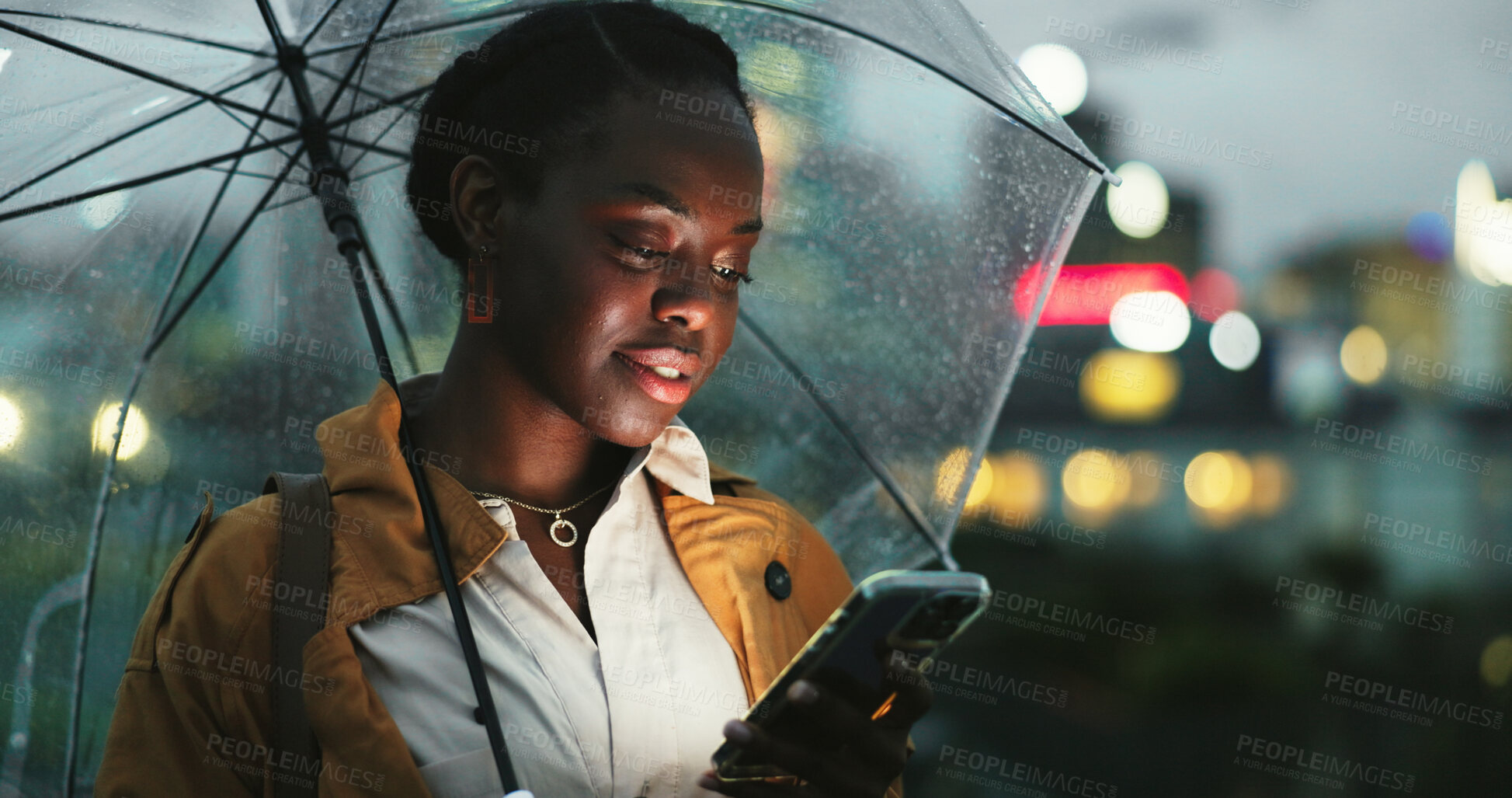 Buy stock photo City, black woman and umbrella with phone at night, text message and chat online on social media. Outdoor, female person and rain protection with cellphone for mobile app, commute and tracking taxi