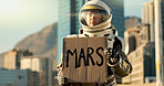 Person, astronaut and billboard with helmet in city for dystopia awareness, message and alert of planet earth. Billboard, poster and travel news for future sustainability, protest sign and mission