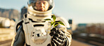 Person, astronaut and outside with plant in road for scientific research, mission and experiment for environment. Spacesuit, outdoor and portrait for growth, discovery and eco friendly project