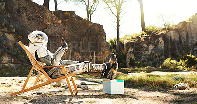 Buy stock photo Relax, nature and astronaut with beer on camping trip for vacation, holiday or getaway in Norway. Person, cooler box and space pilot with drink and resting outdoor in woods for weekend chill on break