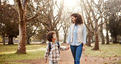 Buy stock photo Holding hands, mother and child walking to school with safety, bonding and backpack in park together. Happy, woman and son on outdoor garden path for morning commute with love, trust and support.