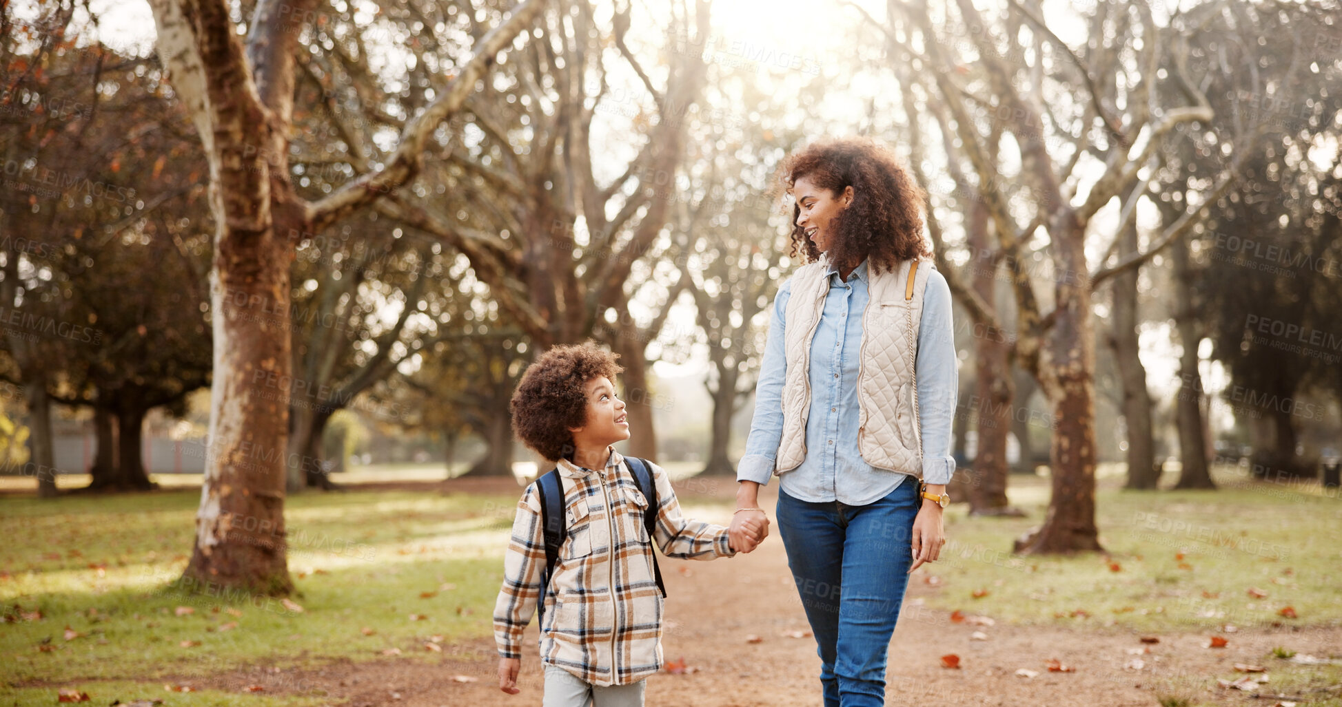 Buy stock photo Holding hands, mother and child walking to school with safety, bonding and backpack in park together. Happy, woman and son on outdoor garden path for morning commute with love, trust and support.